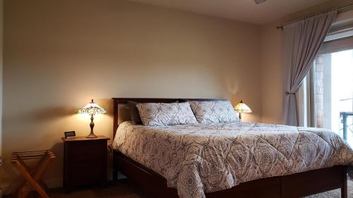 a bedroom with a bed with two lamps and a window at Riverview Retreat in Seaside