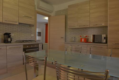 a kitchen with a glass table and chairs at Villa Artemia in Manerba del Garda