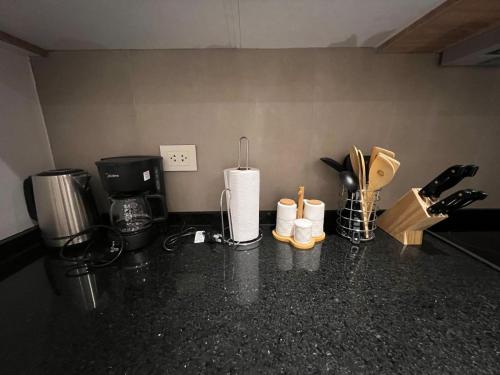 a kitchen counter top with utensils and appliances at Gomez de castro apartments in Asuncion