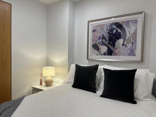a bedroom with a white bed with black pillows at Palko - Stylish in the City in Canberra