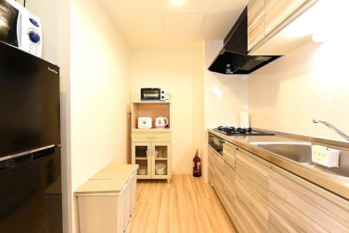 a small kitchen with a sink and a counter at GLASS Yamahana EAST in Minami-jūichijō