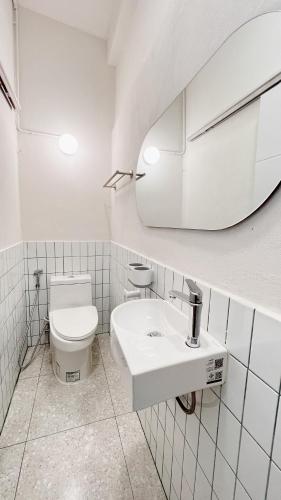 a bathroom with a toilet and a sink and a mirror at La Moon House in Salaya