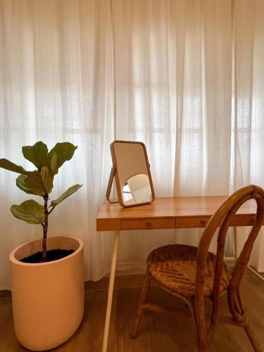 a desk with a mirror and a plant and a chair at La Moon House in Salaya
