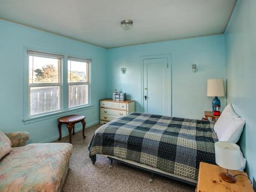 a bedroom with blue walls and a bed and a table at Jim's House in Seaside