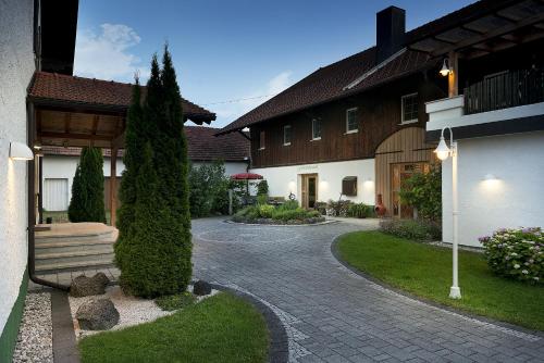 eine Kopfsteinpflastereinfahrt vor einem Haus in der Unterkunft Hotel Oedhof in Freilassing
