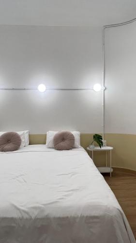 a bedroom with a large white bed with two pillows at La Moon House in Salaya