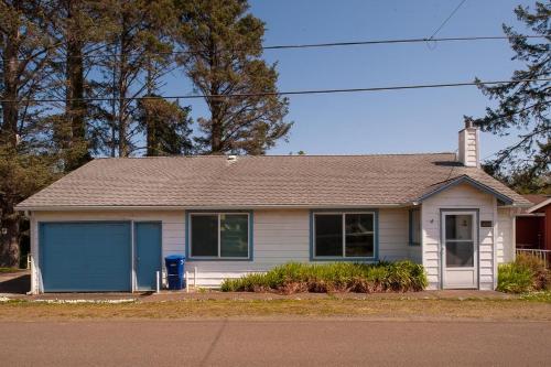 a small white house with a blue garage at The Lighthouse in Lincoln City in Lincoln City