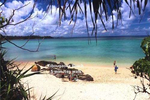 a group of people on a beach near the water at にらい恩納　杉の木 in Onna
