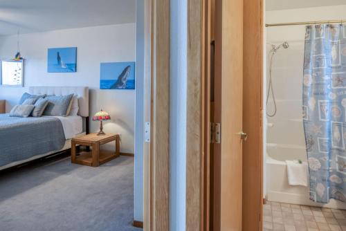 a bedroom with a bed and a bathroom with a shower at Drop Anchor in Waldport
