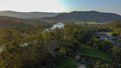 an aerial view of a river with mountains in the background at Chalé Alpino in Apiúna