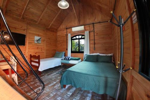 una camera con un letto in una cabina di legno di Chalé Alpino a Apiúna