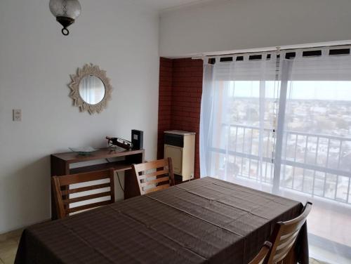 a dining room with a table and a large window at Bravard suites in Bahía Blanca