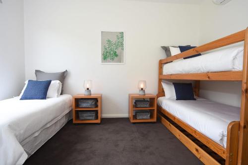 1 Schlafzimmer mit 2 Etagenbetten und 2 Lampen in der Unterkunft Rolling Waves in Pt Leo in Shoreham