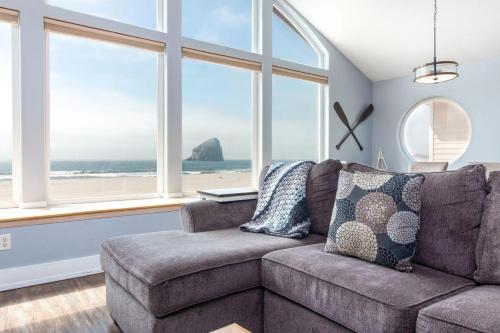 a living room with a couch and some windows at Serendipity by the Sea in Pacific City