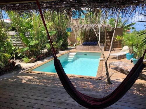 a hammock in front of a swimming pool at LE BUNGA gîte côté canne in Grand-Bourg