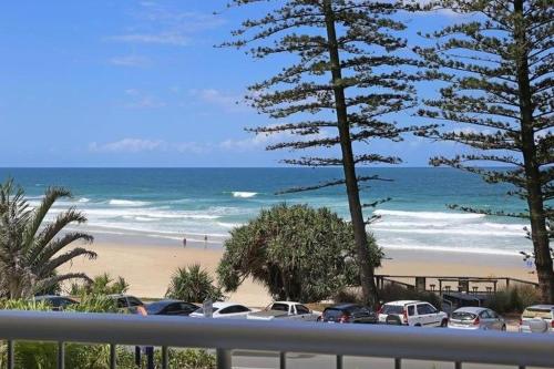 a view of a beach with cars parked on the sand at Coolum Caprice in Coolum Beach