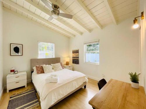 una camera con letto bianco e tavolo in legno di Tropical Oasis House Private Pool Family Yard a Fort Lauderdale