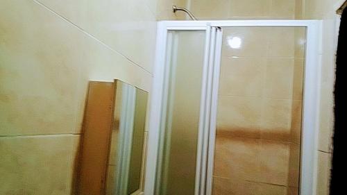 a shower with a glass door next to a shower at Myto in Newcastle