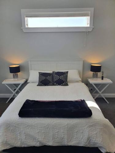 a bedroom with a large bed with two tables at Tauranga - Big, beautiful Villa on the water! in Tauranga