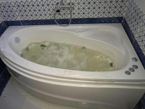 a bath tub filled with water in a bathroom at Alnahas St. Two-Bedroom Apartment With Jacuzzi in Tanta