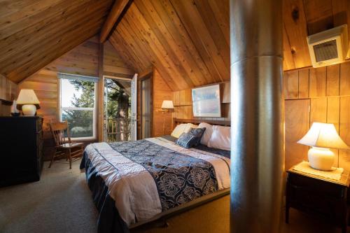 um quarto com uma cama num chalé de madeira em The Cedar House em Otter Rock