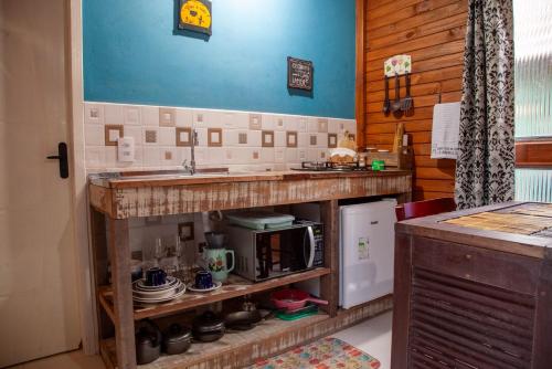a kitchen with a counter with a sink and a microwave at Casa Di Fiori in Apiúna