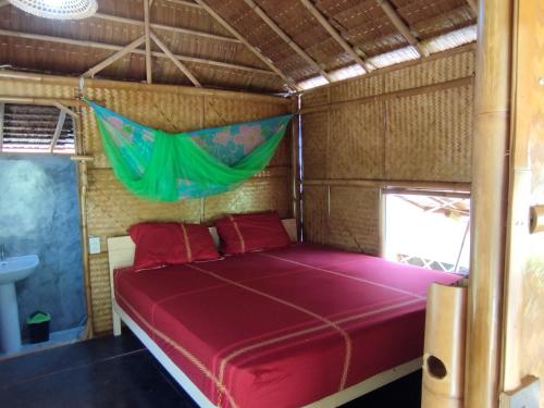 a bed in a room with a red bed at Palm Garden Bungalows in Ko Lanta