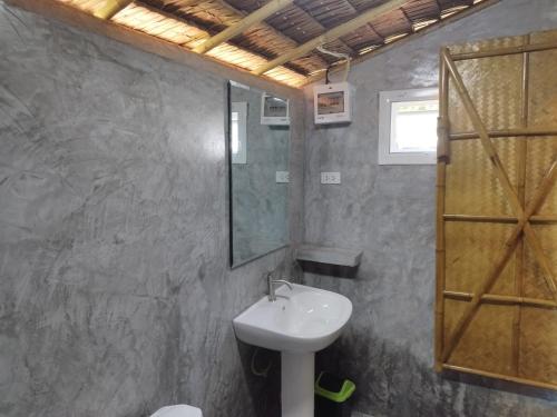 La salle de bains est pourvue d'un lavabo et d'un miroir. dans l'établissement Palm Garden Bungalows, à Ko Lanta