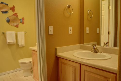 a bathroom with a sink and a toilet and a mirror at Waters Edge 312 in Lincoln City