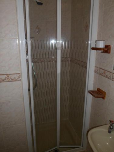 a shower with a glass door in a bathroom at Camelot Hotel - Couples Only in Blackpool