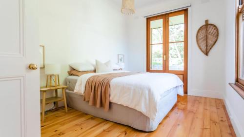 Un dormitorio blanco con una cama y una ventana. en Mendi-Moke, en Flinders