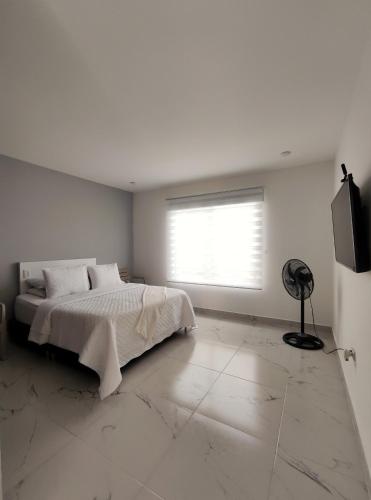 a white bedroom with a bed and a window at Cabañas Compostela Gigante in Gigante
