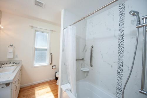 a white bathroom with a shower and a sink at Whale Crossing in Depoe Bay