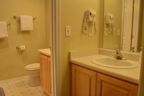 a bathroom with a sink and a toilet and a mirror at Waters Edge 308 in Lincoln City