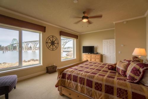 a bedroom with a bed and two large windows at Windward at the Regatta in Newport