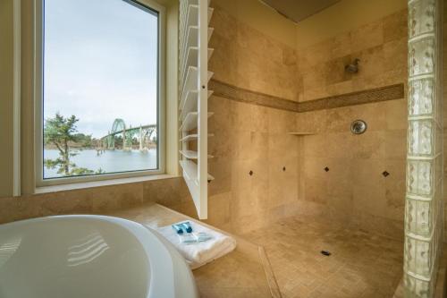 a bathroom with a tub and a shower with a window at Windward at the Regatta in Newport