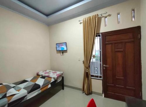 a bedroom with a bed and a door and a window at Private guest house in Pulauberayan