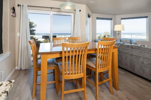 a dining room with a table and chairs and a couch at Beverly Beach Overlook in Newport
