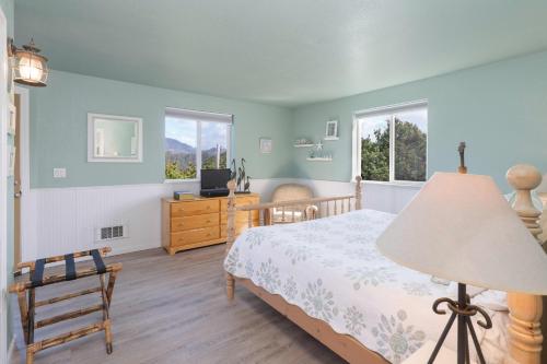 a bedroom with a bed and a chair and two windows at Beverly Beach Overlook in Newport