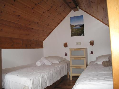 deux lits dans une chambre avec plafonds en bois dans l'établissement Charmant 4 pièces pour 6 pers., à 300m des pistes avec Wi-Fi, balcon et parking, Villeneuve - FR-1-762-3, à La Salle Les Alpes