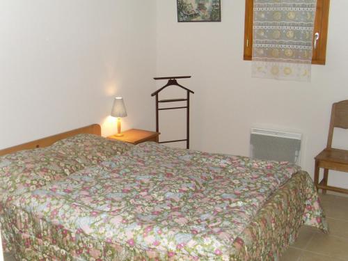 ein Schlafzimmer mit einem Bett, einer Lampe und einem Stuhl in der Unterkunft Appartement 3 pièces, Wi-Fi, Parking, proche des pistes - Briançon - FR-1-762-36 in Briançon