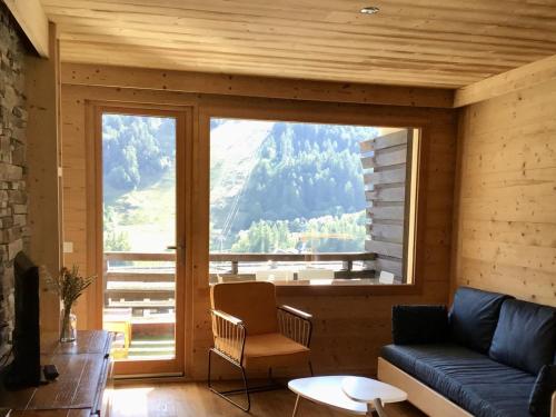 un salon avec un canapé et une grande fenêtre dans l'établissement Appartement 2 Pièces + Coin Montagne pour 6 avec Parking et Wi-Fi - FR-1-762-20, à Saint-Chaffrey