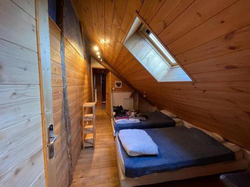 Cette chambre mansardée comprend 3 lits et une fenêtre. dans l'établissement Luxueux Chalet 10 Pers, 5 Ch, 2 Sdb, Jardin, Proche Pistes - Serre Chevalier Villeneuve - FR-1-762-48, à La Salle Les Alpes