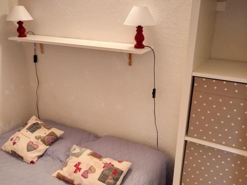 - une chambre avec un lit avec deux oreillers et une étagère dans l'établissement Studio confortable Centre station Terrasse - FR-1-425-204, à Arâches-la-Frasse