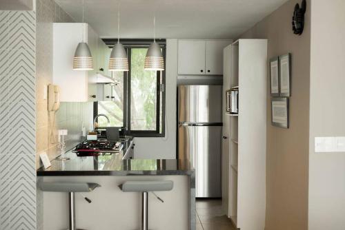 a kitchen with a counter and a refrigerator at NUEVO depto - Glorieta Chapalita in Guadalajara