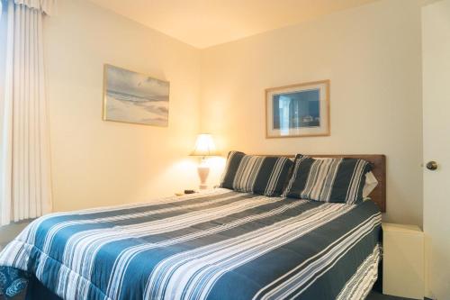 a bedroom with a bed with a blue and white blanket at Dock of The Bay #105 in Lincoln City