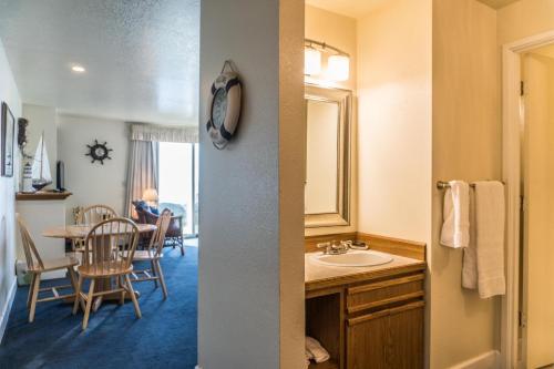 a bathroom with a sink and a dining room with a table at Dock of The Bay #105 in Lincoln City