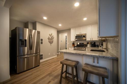 a kitchen with a stainless steel refrigerator and two bar stools at Just Beachy in Lincoln City