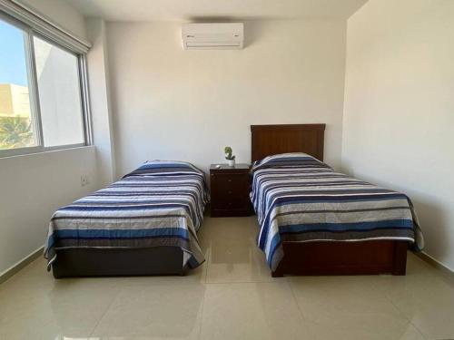 two beds sitting next to each other in a room at Victoria’s Beach house in Heroica Alvarado