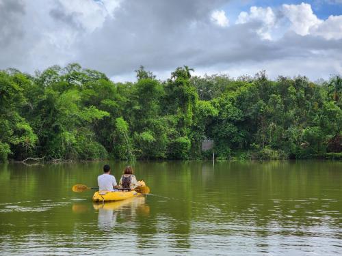 ein Mann und eine Frau auf einem gelben Boot in einem Fluss in der Unterkunft Sawasdee Lagoon Camping & Restaurant in Ban Lam Pi